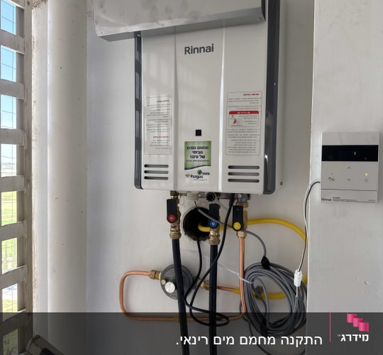 מחמם מים גזי רינאי מותקן על קיר עם צינורות